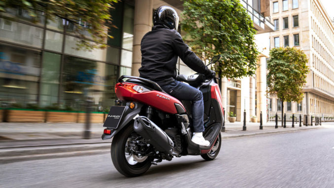 Eine rote yamaha nmax125 fährt 2020 durch eine Großstadt.