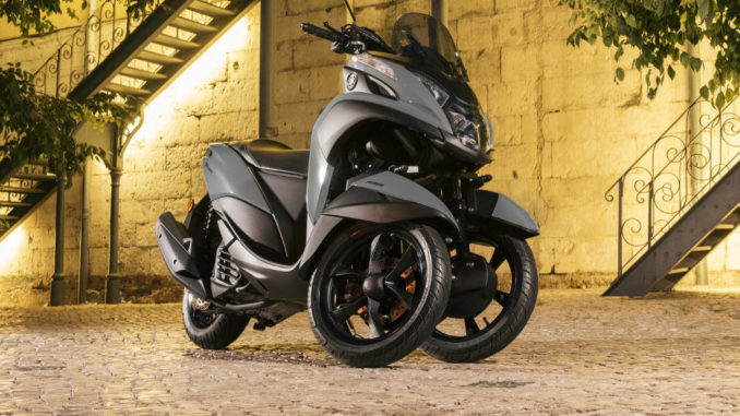 Eine schwarze Yamaha Tricity Modelljahr 2018 steht in einem Hinterhof.